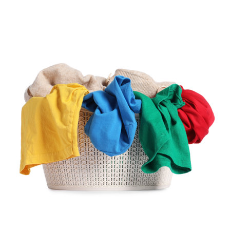 Plastic basket laundry full of colorful clothes isolated on whiteの写真素材