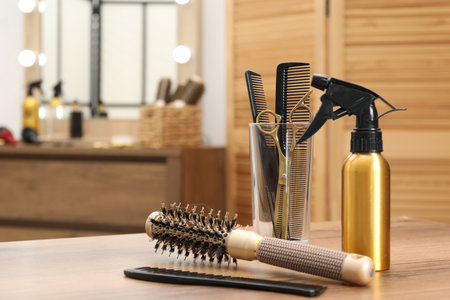 Different hair styling tools on wooden table in salon, closeup. Space for textの写真素材