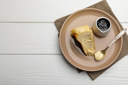 Piece of delicious cheesecake and chocolate sauce on white wooden table, top view. Space for textの写真素材