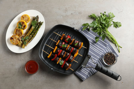Skewers with tasty grilled vegetables served on gray table, flat layの写真素材
