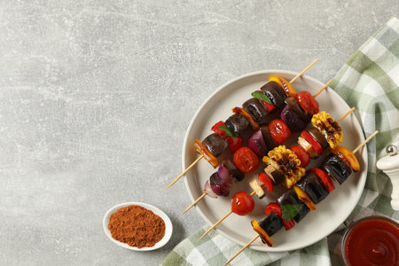 Skewers with tasty grilled vegetables served on gray table, flat lay. Space for textの写真素材
