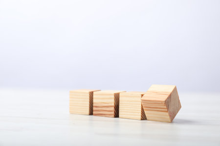 Blank cubes on white wooden table against light background, space for textの写真素材