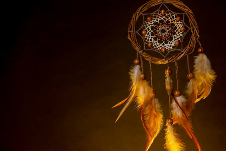 Beautiful dream catcher in color light on dark background. Space for textの写真素材