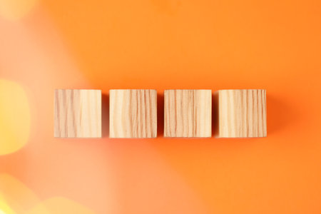 Blank wooden cubes on orange background, flat lay. Bokeh effectの写真素材