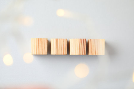 Blank wooden cubes on light gray background, flat lay. Bokeh effectの写真素材