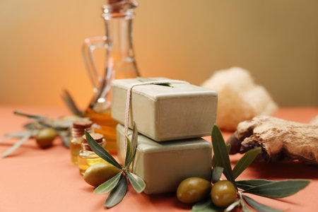 Handmade soap bars, olive, green leaves and oil on color background, closeupの写真素材