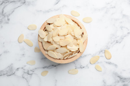 Fresh almond flakes on white marble table, top viewの写真素材