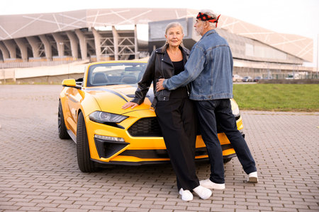 Stylish senior couple near modern cabriolet outdoorsの写真素材