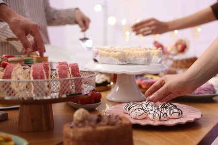 People taking different desserts from buffet table, closeupの写真素材