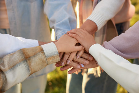 Parents and their children holding hands outdoors, closeup. Family bonding