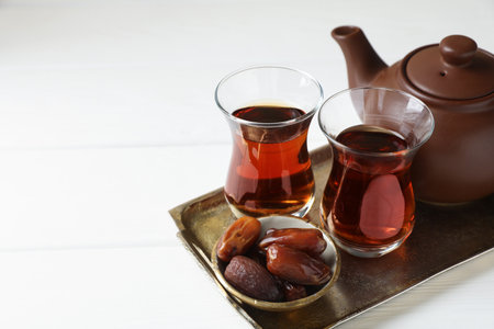 Traditional Turkish tea and dates on white wooden table, closeup. Space for textの写真素材