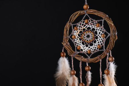 Beautiful dream catcher hanging against black background, closeup. Space for textの写真素材