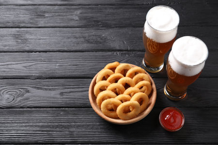 Fried squid rings with sauce and beer served on black wooden table. Space for textの写真素材
