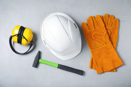 Different safety equipment and hammer on light gray background, flat layの写真素材