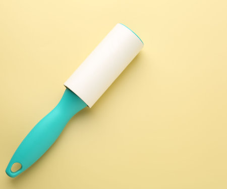 One lint roller on yellow background, top view. Space for textの写真素材