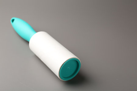 One lint roller on gray background, closeup. Space for textの写真素材