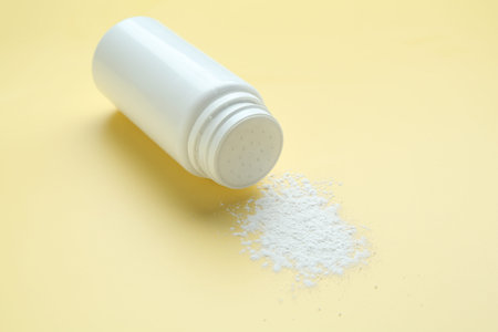 Bottle of talcum powder on yellow background, closeupの写真素材
