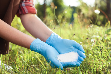 Woman with fertilizer outdoors, closeup. Gardening timeの写真素材