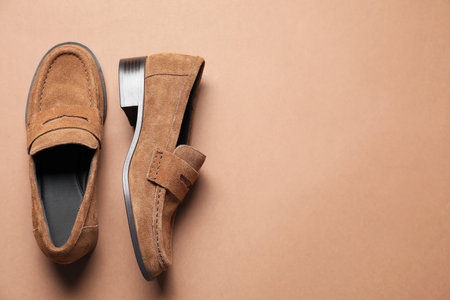 Pair of stylish chamois leather shoes on brown background, top view. Space for textの写真素材