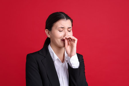 Businesswoman in suit on red backgroundの写真素材