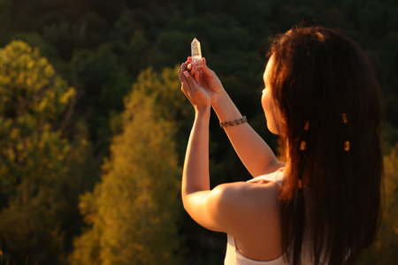 Woman meditating with crystal to heal or restore her aura outdoors, space for textの写真素材