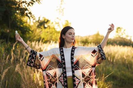 Woman meditating with crystal to heal or restore her aura outdoorsの写真素材