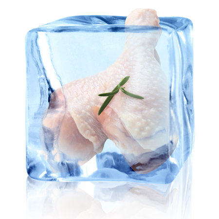 Raw chicken drumsticks in ice cube on white background. Fresh meatの写真素材