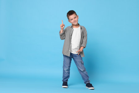 Cute little boy on light blue backgroundの写真素材