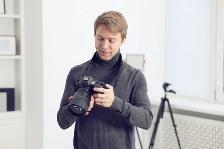 Professional photographer with camera working in studio