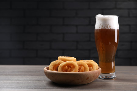 Fried squid rings and beer served on wooden table. Space for textの写真素材