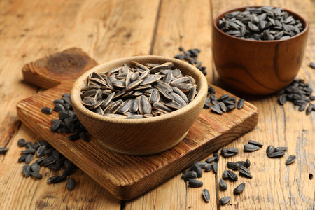 Unpeeled sunflower seeds on wooden table, closeupの写真素材