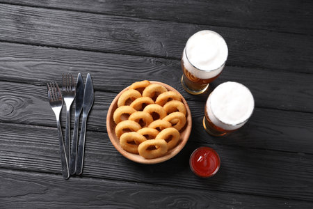 Fried squid rings with sauce served on black wooden table, flat layの写真素材