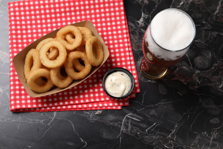 Fried squid rings with sauce served on black marble table, flat layの写真素材