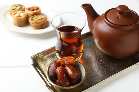 Traditional Turkish tea, dates and sweets on white wooden table, closeupの写真素材