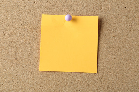 Blank note pinned on cork board, space for text