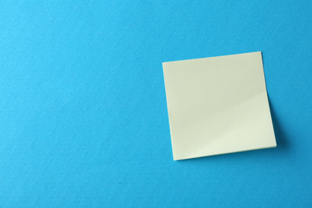 Blank yellow notes on light blue background, top view. Space for textの写真素材