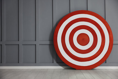 Round shooting target on floor near gray wall, space for textの写真素材