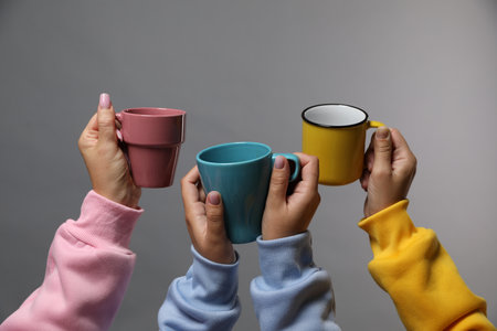 Friends with colorful cups on gray background, closeupの写真素材