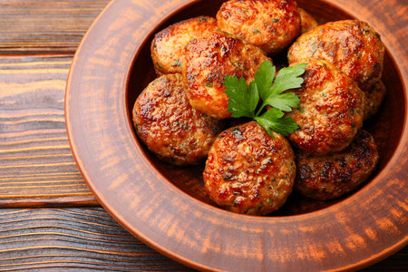 Delicious meat patties with parsley on wooden table, closeupの写真素材