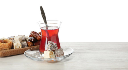 Traditional Turkish tea and desserts on wooden table against white backgroundの写真素材