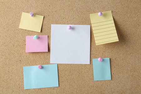 Blank colorful notes pinned on cork board, space for text