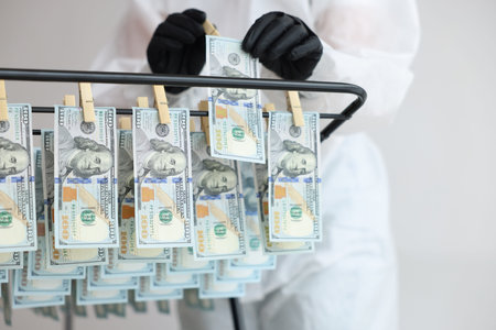 Money laundering. Woman hanging banknotes on drying rack indoors, closeupの写真素材