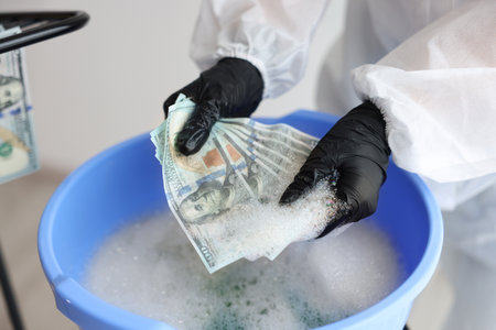 Money laundering. Woman washing dollar banknotes in basin indoors, closeupの写真素材