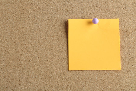 Blank note pinned on cork board, space for textの写真素材