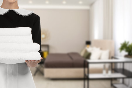 Chambermaid with clean towels in hotel room, closeupの写真素材