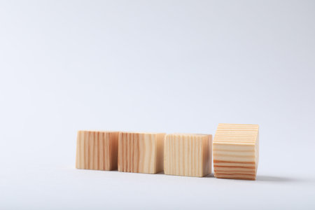 Blank wooden cubes on light background, closeup. Space for text