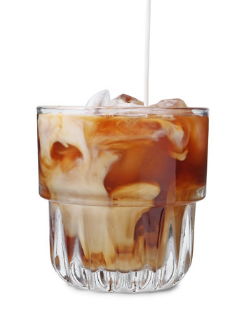 Pouring milk into iced coffee on white background, closeup