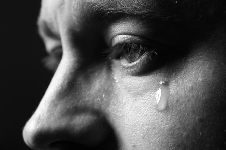 Sad man crying on dark background, closeup. Black and white effectの写真素材