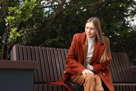 Young woman suffering from stomach ache and nausea outdoors, space for textの写真素材