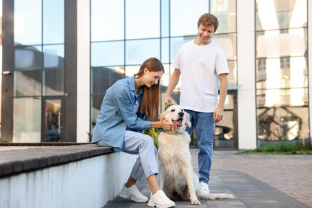 Couple with their adorable golden retriever dog in on city street